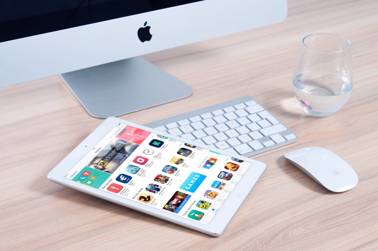 Sleek home office setup featuring an iMac and iPad showcasing apps.